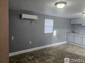 Gibsonton apartment for rent - A room with a window, a wall-mounted air conditioner, and a carpeted floor.