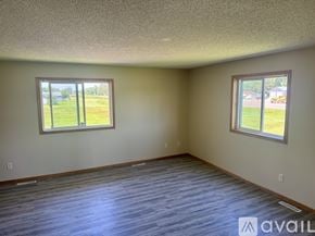 Foreston apartment for rent - A room with two windows and a wooden floor.