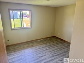 Foreston apartment for rent - A room with a window showing a view of a field and a building.
