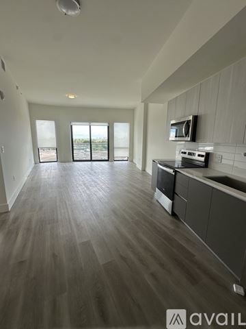 Oakland Park apartment for rent - A spacious kitchen with a microwave above the stove and a large window.