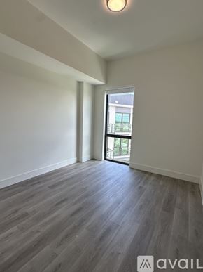 Oakland Park apartment for rent - A room with wooden flooring and a window leading to a balcony.
