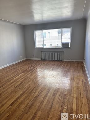 Denver apartment for rent - A room with wooden flooring and a window with blinds.