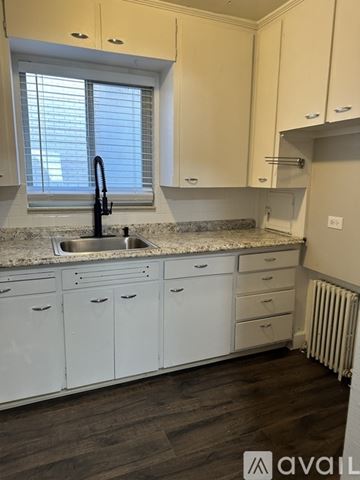 Denver apartment for rent - A kitchen with white cabinets and a black faucet.