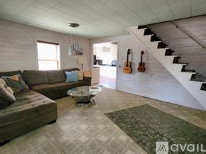 Marquette house for rent - A living room with a couch, a coffee table, and a staircase.