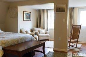 Marquette house for rent - A bedroom with a bed, chair, and a painting on the wall.