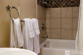 Marquette house for rent - A bathroom with a tub, towel rack, and a shower curtain.