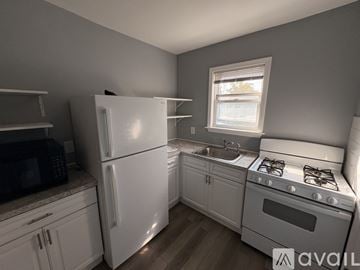 Taunton apartment for rent - A kitchen with white appliances and wooden floors.