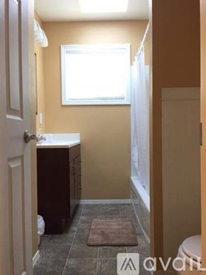 Cheney apartment for rent - A bathroom with a toilet, sink, and window.