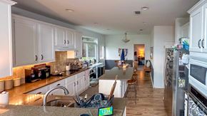 Austin house for rent - A kitchen with white cabinets and a wooden floor.