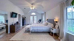Austin house for rent - A bedroom with a large bed and a ceiling fan.
