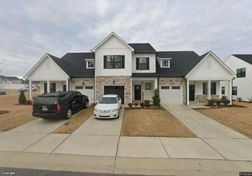 Zebulon house for rent - A white house with a black car and a white car parked in front.