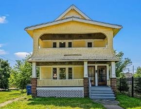 Cleveland apartment for rent - A yellow house with a black fence in front.