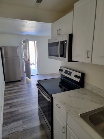 Herriman house for rent - A kitchen with a stove top oven and a microwave above it.