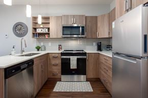 Leduc apartment for rent - A modern kitchen with a stainless steel refrigerator and wooden cabinets.