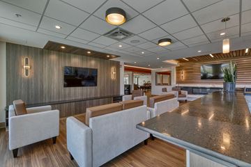 Leduc apartment for rent - A modern living room with a long table and grey couches.