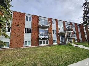 Edmonton apartment for rent - A red brick apartment building with white trim and balconies.
