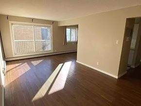 Edmonton apartment for rent - A room with wooden floors and two windows.