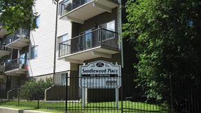 Edmonton apartment for rent - A sign for Sandlewood Place is in front of a building.