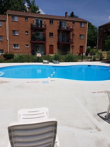 Riverside apartment for rent - A chair is in the foreground of a swimming pool.