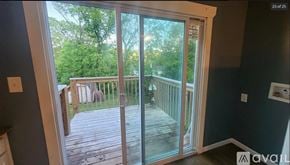 Oak Ridge apartment for rent - A balcony with glass doors leading to a deck surrounded by trees.