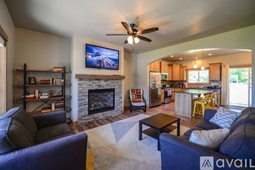 Coeur D'alene house for rent - A living room with a fireplace and a television on the wall.