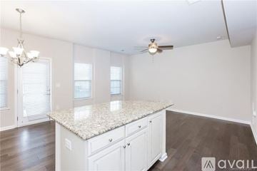 Concord house for rent - A kitchen with white cabinets and a granite countertop.