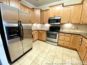 Fayetteville townhouse for rent - A kitchen with wooden cabinets and a stainless steel refrigerator.