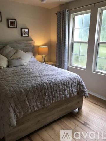 Fuquay Varina apartment for rent - A bedroom with a large bed and a window with curtains.