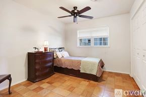 Baton Rouge house for rent - A bedroom with a bed, dresser, and window.
