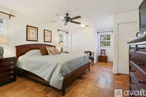 Baton Rouge house for rent - A bedroom with a large bed and a ceiling fan.