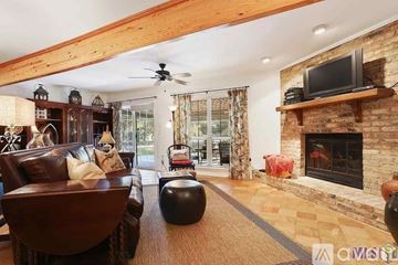 Baton Rouge house for rent - A living room with a fireplace and a television on the wall.