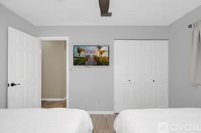 Titusville house for rent - A bedroom with two beds and a painting on the wall.
