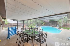 Titusville house for rent - A patio with a table and chairs and a pool.