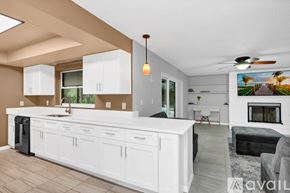 Titusville house for rent - A modern kitchen with white cabinets and a large island.