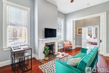 Savannah apartment for rent - A living room with a green couch and a fireplace.