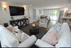 Bristol house for rent - A living room with a white couch and a flat screen TV mounted on the wall.