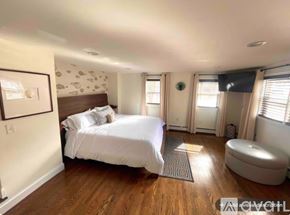 Bristol house for rent - A bedroom with a large bed and a round ottoman.