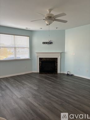 Selbyville condo for rent - A room with a fireplace and a fan.