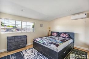 Garden Grove house for rent - A bedroom with a black bed and a Star Wars comforter.