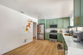 Garden Grove house for rent - A kitchen with green cabinets and a white wall with drawings on it.