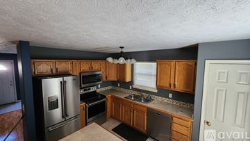 West Lafayette house for rent - A kitchen with wooden cabinets and stainless steel appliances.