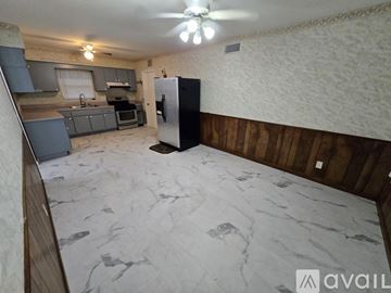 Seminole house for rent - A kitchen with a black fridge and wooden walls.