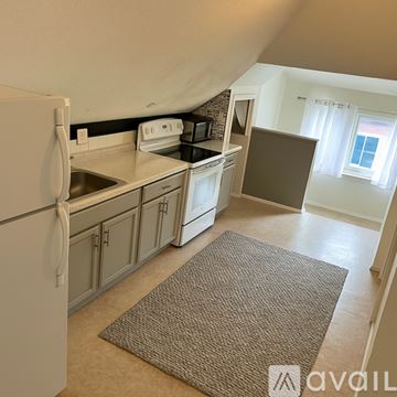 Portland apartment for rent - A kitchen with a white refrigerator and a brown rug on the floor.