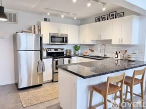 Phoenix apartment for rent - A modern kitchen with a stainless steel refrigerator, microwave, oven, and sink.