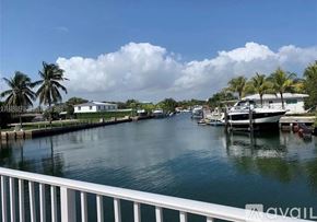 North Miami apartment for rent - A view of a waterway with boats and houses on the side.