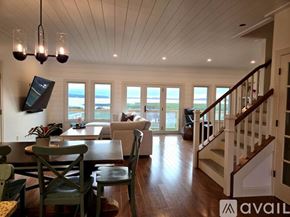 Onekama house for rent - A living room with a wooden floor and a staircase.