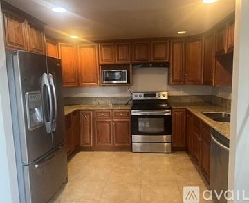 San Diego townhouse for rent - A kitchen with wooden cabinets and stainless steel appliances.