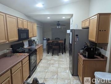 Phoenix house for rent - A kitchen with wooden cabinets and a black fridge.
