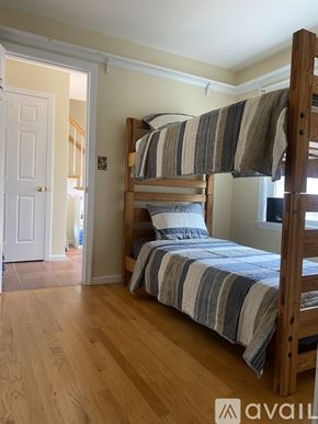 Onset house for rent - A bedroom with a bed and a wooden floor.