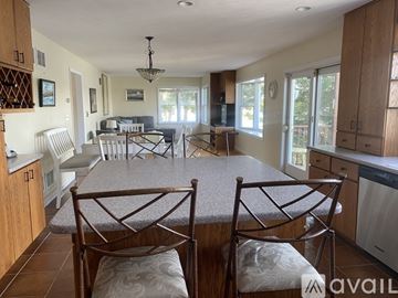 Onset house for rent - A kitchen with a table and chairs in the foreground.